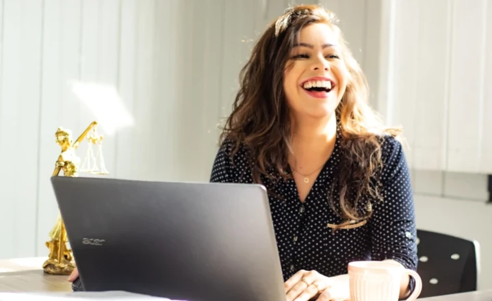 Femme souriante travaillant sur son ordinateur au bureau