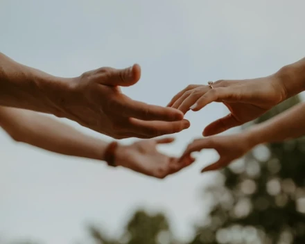 Mains de mariés se touchant délicatement lors de la cérémonie de mariage